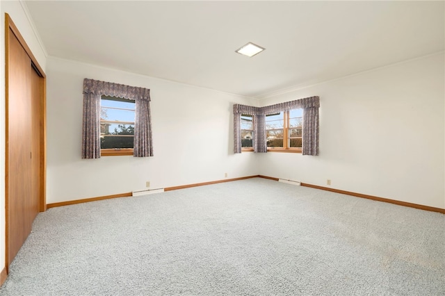 carpeted empty room with baseboards, a baseboard radiator, and a healthy amount of sunlight