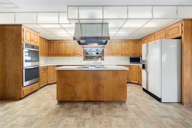 kitchen with white fridge with ice dispenser, light countertops, a kitchen island, and double oven