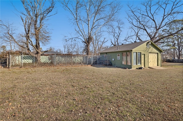 view of yard with a garage and a fenced backyard