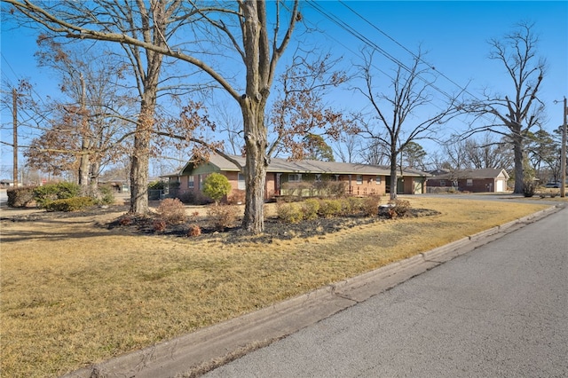 ranch-style home featuring a garage, driveway, a residential view, and a front yard