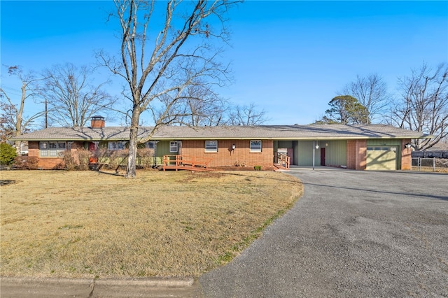 ranch-style home with an attached garage, brick siding, aphalt driveway, and a front yard