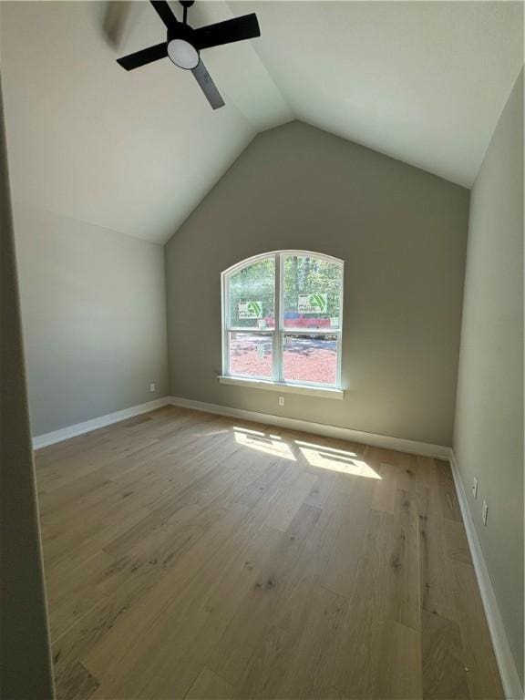 additional living space featuring a ceiling fan, lofted ceiling, baseboards, and light wood finished floors