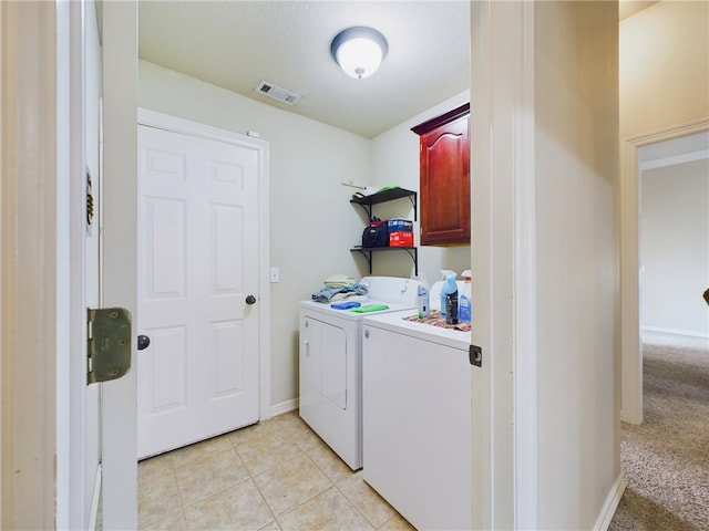 laundry room with cabinet space, visible vents, baseboards, washing machine and clothes dryer, and light tile patterned flooring