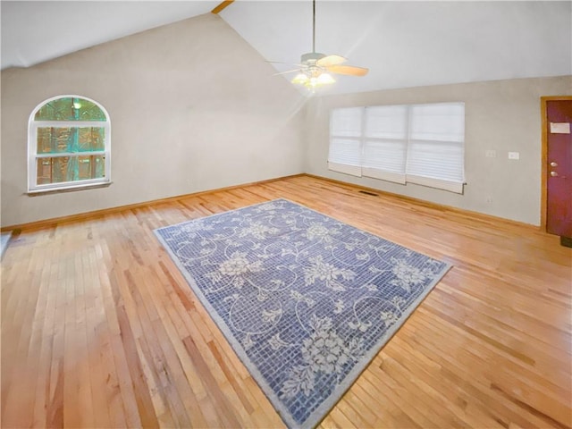 unfurnished living room featuring ceiling fan, vaulted ceiling, and wood finished floors