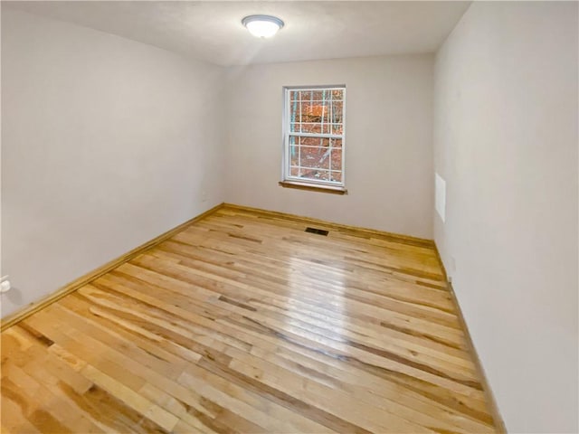 unfurnished room with visible vents and wood finished floors