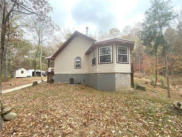 view of side of property with crawl space and central AC unit