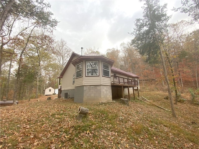 view of side of home with cooling unit and a wooden deck