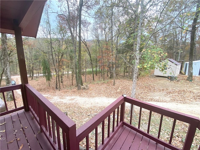 wooden deck with a storage shed and an outbuilding