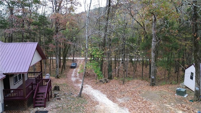 view of yard featuring dirt driveway and stairs