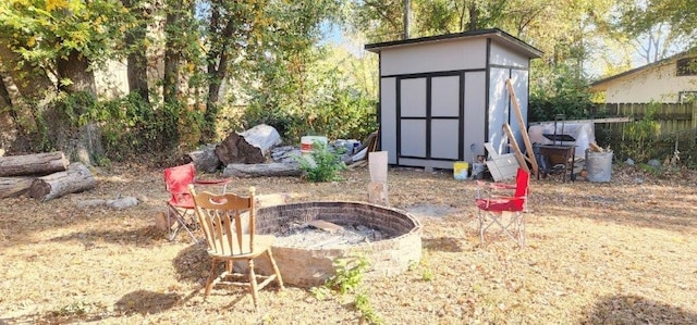 view of shed featuring fence and a fire pit