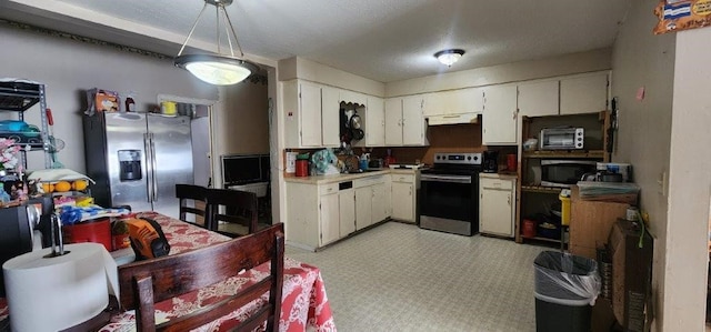 kitchen with light floors, stainless steel appliances, light countertops, white cabinetry, and under cabinet range hood