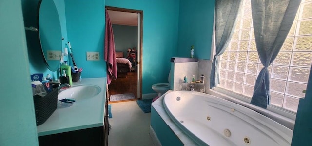 bathroom featuring ensuite bathroom, a tub with jets, a sink, and toilet