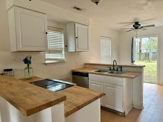 kitchen with a sink, a kitchen island, white cabinetry, and stainless steel dishwasher