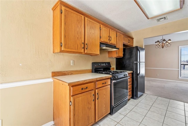 kitchen featuring brown cabinets, light countertops, visible vents, under cabinet range hood, and black appliances