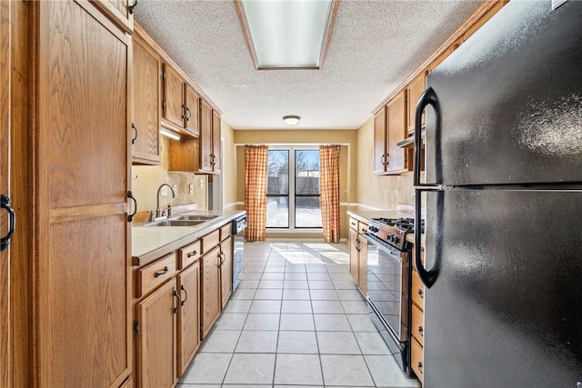 kitchen featuring light tile patterned floors, light countertops, appliances with stainless steel finishes, a sink, and under cabinet range hood