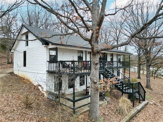 view of front of home featuring covered porch and stairs