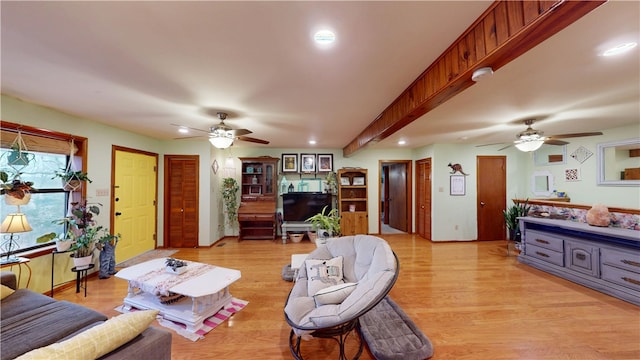 living area featuring light wood-style flooring, a ceiling fan, beamed ceiling, and recessed lighting