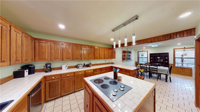 kitchen with brown cabinets, tile countertops, a kitchen island, electric stovetop, and dishwasher