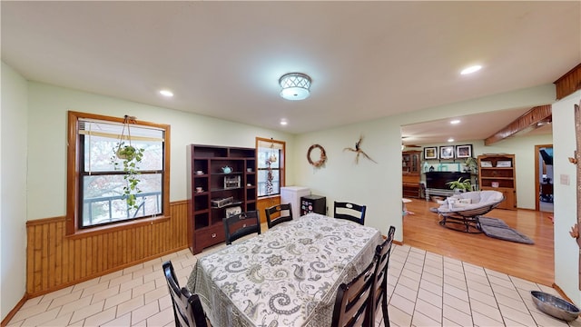 dining space featuring a wainscoted wall, light wood finished floors, recessed lighting, and wooden walls