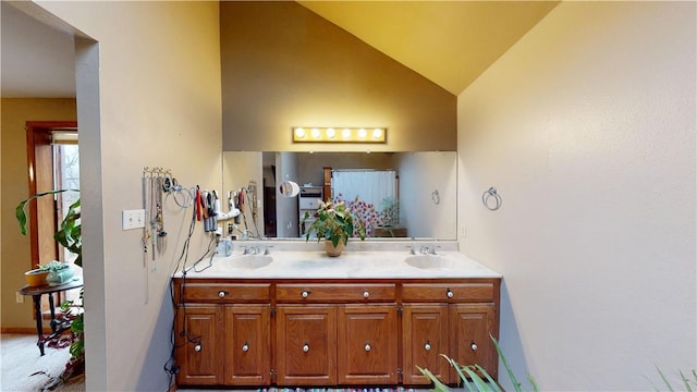 full bathroom with lofted ceiling, double vanity, and a sink