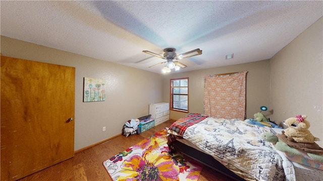 bedroom featuring a textured ceiling, ceiling fan, wood finished floors, and baseboards