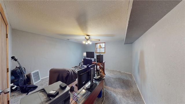 carpeted office space with a textured ceiling, a ceiling fan, and a textured wall