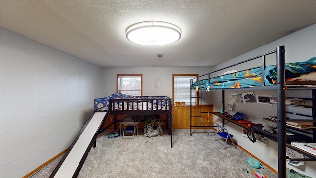 carpeted bedroom with visible vents, baseboards, and a textured ceiling