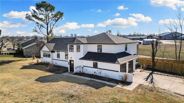 view of front of home with concrete driveway, fence, a garage, a residential view, and a front lawn