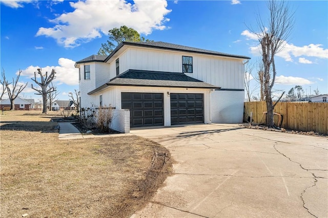 view of side of home with driveway, an attached garage, fence, and brick siding