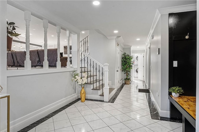 foyer entrance featuring recessed lighting, stairway, ornamental molding, stacked washer / dryer, and baseboards