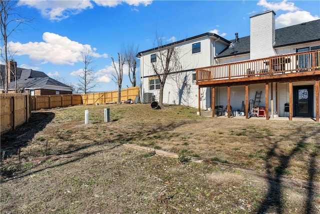 back of house featuring a yard, a fenced backyard, and a wooden deck