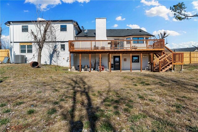 back of house featuring central AC unit, a lawn, a chimney, stairs, and a wooden deck