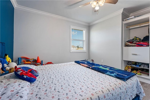 bedroom with wood finished floors, crown molding, and ceiling fan