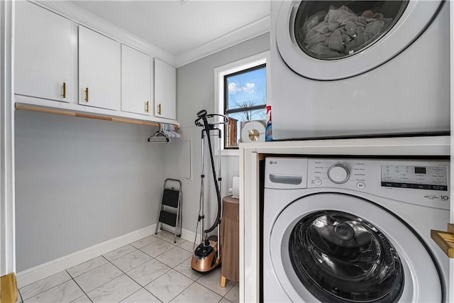 laundry room with baseboards, marble finish floor, ornamental molding, cabinet space, and stacked washer and clothes dryer
