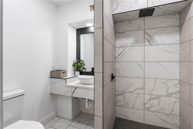 full bath featuring a walk in shower, toilet, a sink, baseboards, and marble finish floor
