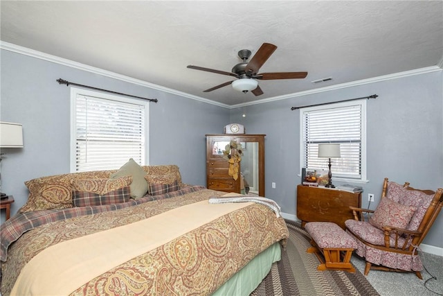 carpeted bedroom with visible vents, crown molding, baseboards, and ceiling fan