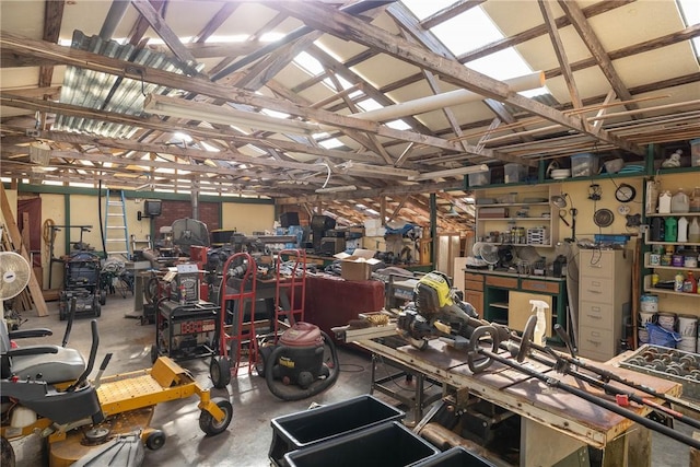 miscellaneous room with lofted ceiling, concrete floors, and a workshop area