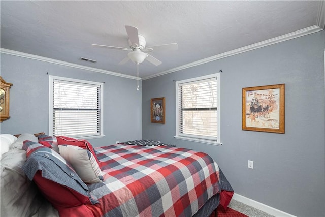 carpeted bedroom featuring baseboards, visible vents, ceiling fan, and crown molding