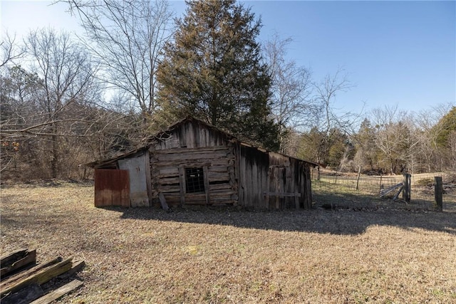 view of outbuilding featuring an outdoor structure and fence