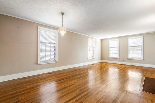 510 W Central Ave, Bentonville, AR 72712 - spare room with a textured ceiling, baseboards, wood finished floors, and a chandelier