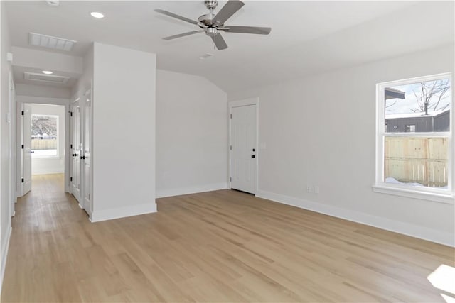 empty room featuring visible vents, attic access, light wood-style flooring, and baseboards