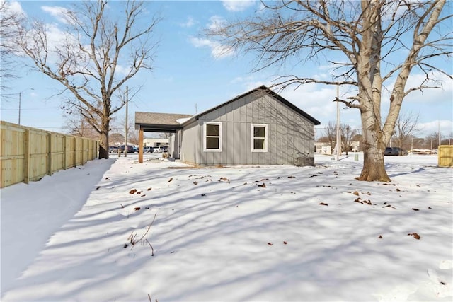 snow covered property with fence