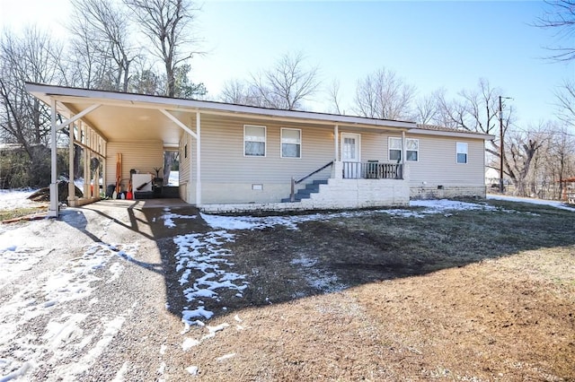 view of front of house featuring driveway, crawl space, and a carport