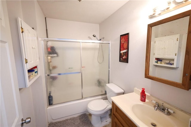 bathroom featuring enclosed tub / shower combo, vanity, and toilet