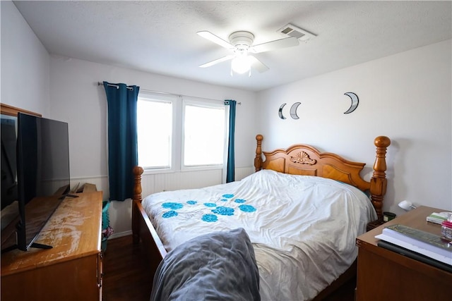 bedroom featuring dark wood-style floors, visible vents, and ceiling fan