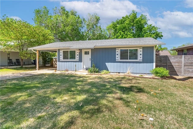 view of front of home with fence, a front lawn, a carport, and concrete driveway