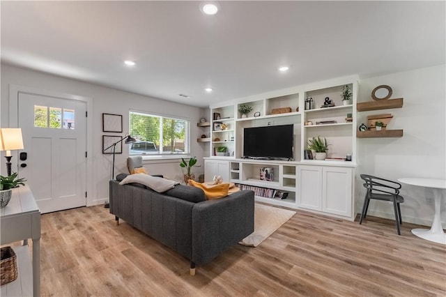 living area featuring baseboards, light wood-type flooring, and recessed lighting