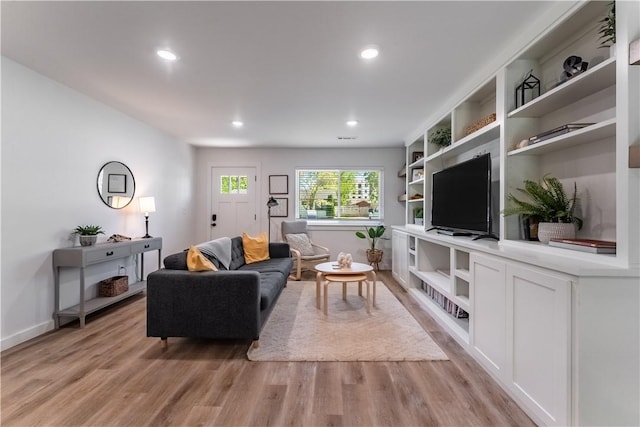 living room featuring light wood finished floors, baseboards, and recessed lighting