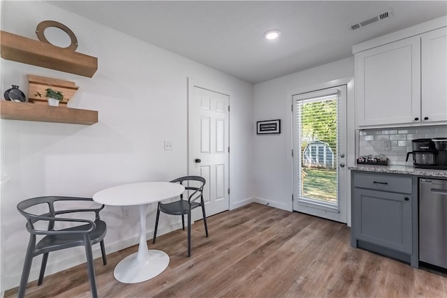 dining space featuring wood finished floors, visible vents, and baseboards