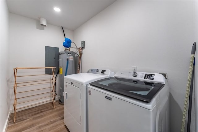 laundry room featuring electric water heater, recessed lighting, electric panel, light wood finished floors, and washing machine and clothes dryer